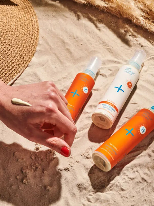 natural sunburn bottles in the sand, drop on hand