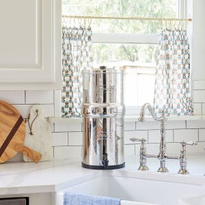 Berkey water filter in kitchen, at sink in front of window