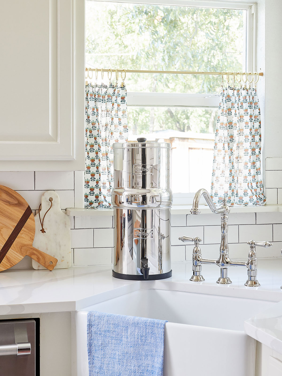 Berkey water filter in kitchen, at sink in front of window