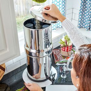 Une femme ouvre le couvercle du filtre à eau Berkey