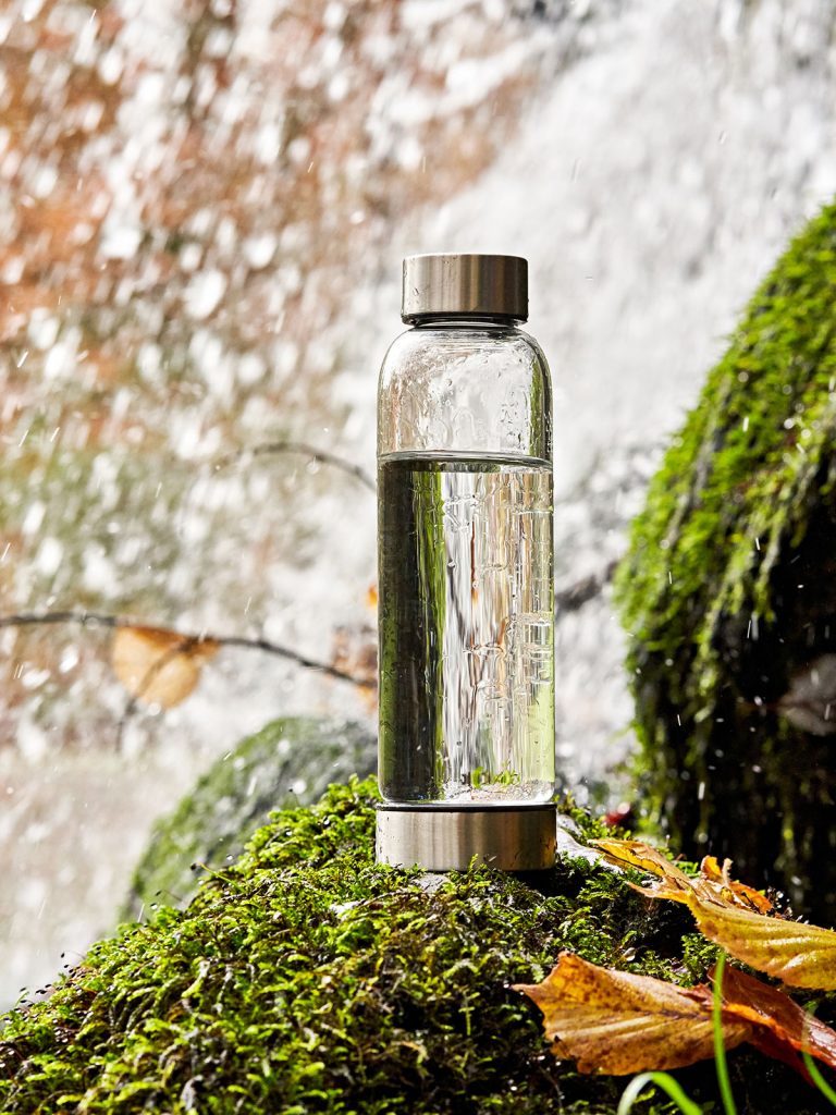 Bo-Bottle Trinkflasche auf moosbewachsenem Stein für Wasserfallwasser