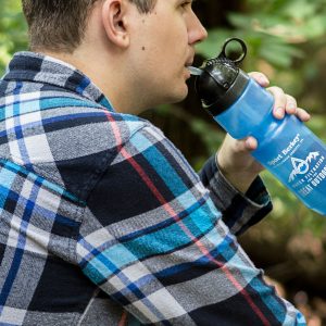 Homme buvant dans une bouteille de sport Berkey bleue, nature