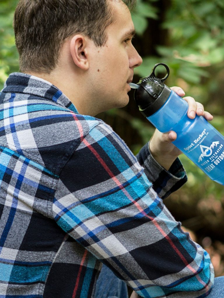 Man drinks from Berkey Sport drinking bottle blue, nature